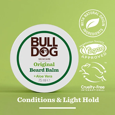 Image 2 - A round container of Bulldog Skincare Original Beard Balm labeled with the product name, Original Beard Balm + Aloe Vera, and features icons indicating it has natural origin ingredients, is vegan approved, and cruelty-free, set against a green background with the text Conditions & Light Hold at the bottom.
Image 3 - A close-up image of an aloe vera leaf with a glossy gel, featuring text that reads 96% Natural Origin and Unlock the true potential of natural origin ingredients, along with Conditions & Light Hold.
Image 4 - A person is holding a container of Bulldog Original Beard Balm, with the lid being opened to reveal the creamy product inside, and visible text reads For All Beard Types.
Image 5 - A round jar of Bulldog Original Beard Balm is placed on a countertop with visible text stating 98.5% Recycled PCR Plastic Jar and a recycling logo that indicates it is a recycled plastic jar.
Image 6 - Three Bulldog Skincare products for beard care are displayed on a shelf: a small bottle of Original Beard Oil, a larger bottle labeled Original Beard Shampoo & Conditioner, and a round container of Original Beard Balm, with the text Tame Your Beard visible at the bottom.