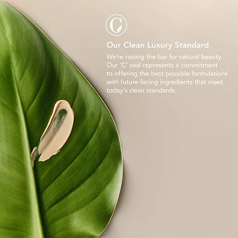 A swatch of foundation rests on a green leaf beside a logo and the text Our Clean Luxury Standard Were raising the bar for natural beauty. Our C seal represents a commitment to offering the best possible formulations with future-facing ingredients that meet todays clean standards.