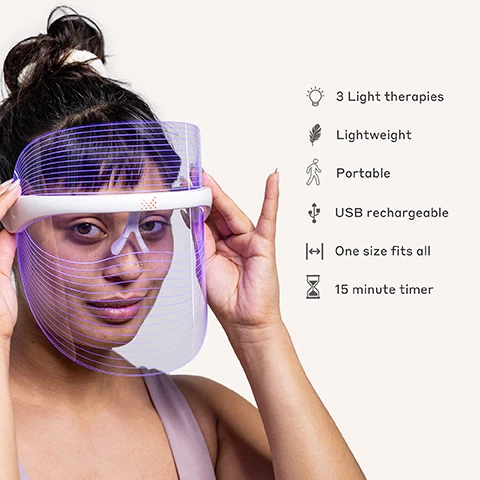 Image 1 - A woman holds a transparent light therapy face mask to her face, showing features related to the product including icons for 3 light therapies, lightweight, portable, USB rechargeable, one size fits all, and a 15 minute timer.
Image 2 - A woman is wearing a transparent face shield with orange lines illuminated on it, smiling, and there are two logos: one indicating platinum 2024 beauty awards winner and another stating Menopause Friendly with an M.
Image 3 - Illustration showing three facial device designs with corresponding LED colors and their benefits; the top section represents Red LED with a wavelength of 620-750nm focusing on lines and wrinkles, the middle section represents Yellow LED with a wavelength of 590-620nm for radiance and glow, and the bottom section represents Blue LED with a wavelength of 476-495nm targeting blemishes and oiliness.
Image 4 - A person wearing a blue LED face mask with lines is displayed on the left, while on the right are text descriptions of its features including Customisable Light Modes, Hands-Free & Comfortable, Boosts Collagen Production, Reduces fine lines & wrinkles, USB Rechargeable, Fights Acne & Breakouts, Reduces Redness & Soothes Skin, and Tri-Colour LED Light Therapy.