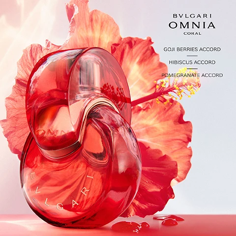 Image 3 - A vibrant red Bvlgari Omnia Coral perfume bottle stands in front of a large red hibiscus flower with a light background, displaying text BVLGARI OMNIA CORAL, GOJI BERRIES ACCORD, HIBISCUS ACCORD, POMEGRANATE ACCORD. Image 5 - Four Bvlgari Omnia perfume bottles are displayed vertically, from left to right: a red Bvlgari Omnia Coral Eau de Toilette bottle with red flowers and the text BVLGARI OMNIA CORAL EAU DE TOILETTE FLORAL FRUITY JUICY LIVELY; a clear Bvlgari Omnia Crystalline Eau de Toilette bottle with white flowers and the text BVLGARI OMNIA CRYSTALLINE EAU DE TOILETTE FLORAL WOODY RADIANT CRISPY; a light gold Bvlgari Omnia Crystalline Eau de Parfum bottle with white flowers and the text BVLGARI OMNIA CRYSTALLINE EAU DE PARFUM FLORAL WOODY GRACEFUL ENVELOPING; and a purple Bvlgari Omnia Amethyste Eau de Toilette bottle with purple flowers and the text BVLGARI OMNIA AMETHYSTE EAU DE TOILETTE FLORAL FLORAL DELICATE POWDERY.