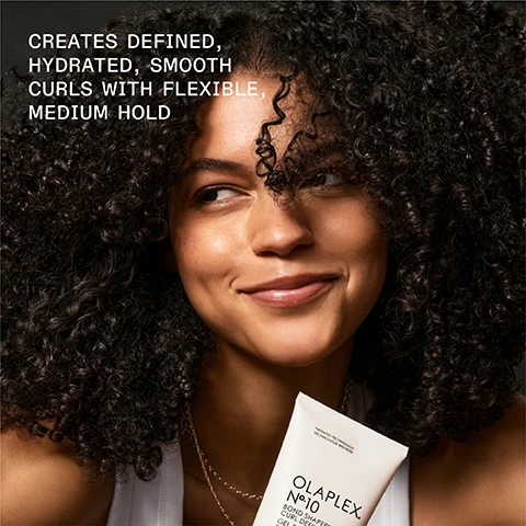 Image 1 - A smiling woman with curly hair holds an Olaplex hair product in her hand, and the image includes the text CREATES DEFINED, HYDRATED, SMOOTH CURLS WITH FLEXIBLE, MEDIUM HOLD.
Image 2 - A tube of Olaplex No. 10 Bond Smoother Curl Defining Gel is shown, with visible text stating 3X GREATER CURL RETENTION and stating that results are clinically proven.
Image 3 - Image shows a comparison of curly hair before and after using specific hair products, with the left side labeled BEFORE displaying frizz and the right side labeled AFTER showing defined curls, accompanied by a note about results varying based on product use.
Image 4 - Side-by-side comparison of hair before and after using OLAPLEX products, showing smoother curls on the right labeled as AFTER and frizzier hair on the left labeled as BEFORE; visible text includes UNRETOUCHED IMAGES and results disclaimer.
Image 5 - A comparison image showing the back of a persons head with curly hair, labeled BEFORE on the left and AFTER on the right, with visible text at the bottom describing the results and products used including OLAPLEX N°4 Bond Maintenance Shampoo and N°5 Bond Maintenance Conditioner.
Image 6 - Image shows two hair care products from Olaplex: a tube of No. 10 Bond Smoothing Gel and a bottle of No. 5 Leave-In Conditioner, with text indicating their benefits for defining curls and moisturizing.