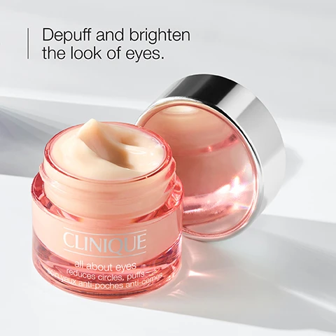 Image 4 - An open jar of Clinique All About Eyes peach-colored cream with its silver lid next to it, on a white surface, with the text Depuff and brighten the look of eyes. CLINIQUE all about eyes reduces circles, puffs soin yeux anti-poches anti-cernes. Image 6 - A close-up split image shows a blue eye with natural eyelashes in the top section and volumized, lengthened eyelashes in the bottom section, illustrating Before After application.