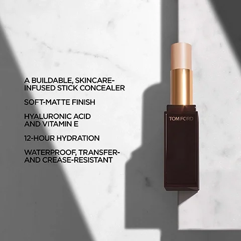 Image 5 - A dark brown and gold stick concealer by Tom Ford stands upright on a white marble surface with shadows, accompanied by text that reads TOM FORD, A BUILDABLE, SKINCARE-INFUSED STICK CONCEALER, SOFT-MATTE FINISH, HYALURONIC ACID AND VITAMIN E, 12-HOUR HYDRATION, WATERPROOF, TRANSFER- AND CREASE-RESISTANT.